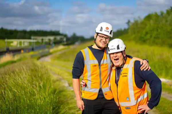 Twee lachende mannen met landschap op achtergrond